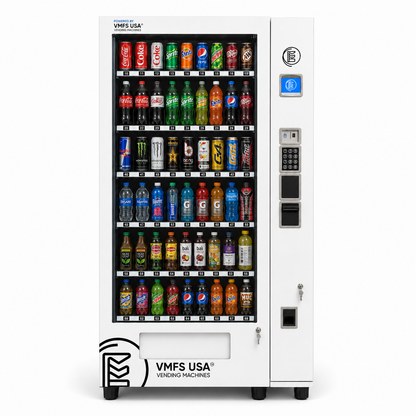 A white commercial beverage vending machine with multiple rows of assorted bottled and canned drinks inside a glass-front display area, plus a payment panel on the right side. The machine is branded VMFS USA.