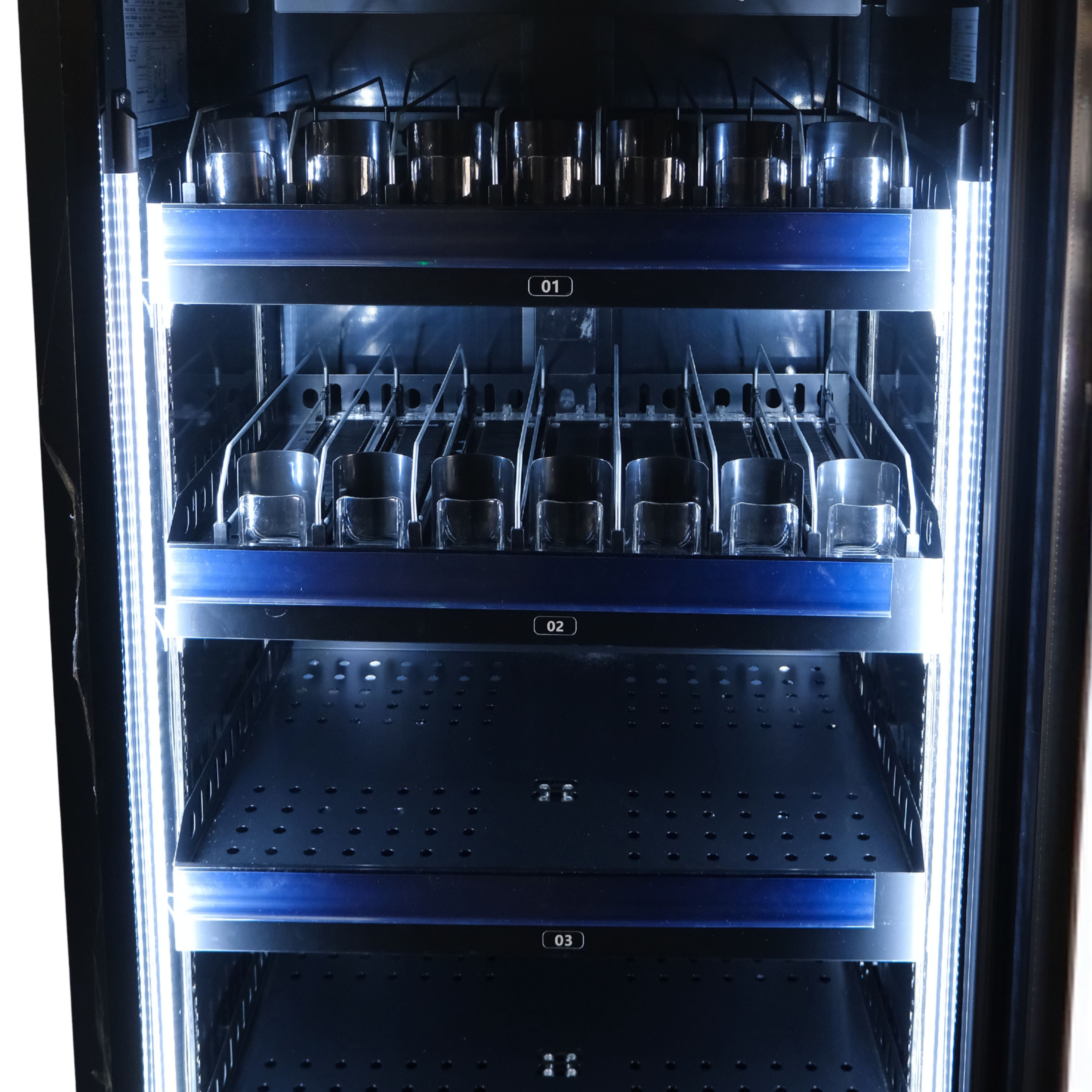 Vending machine with multiple compartments containing metal cups.
